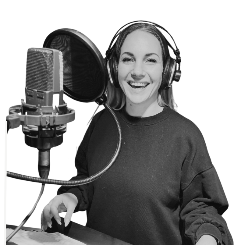 Daniela Blöcker Foto Ein Bild von Daniela Blöcker, auf dem im Tonstudio steht und gerade etwas einspricht. Sie steht vorm Mikrofon.